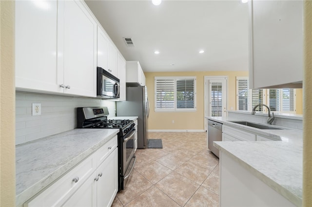 kitchen featuring a sink, visible vents, white cabinets, appliances with stainless steel finishes, and tasteful backsplash