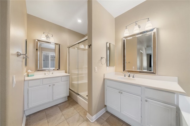 bathroom with a stall shower, two vanities, and a sink