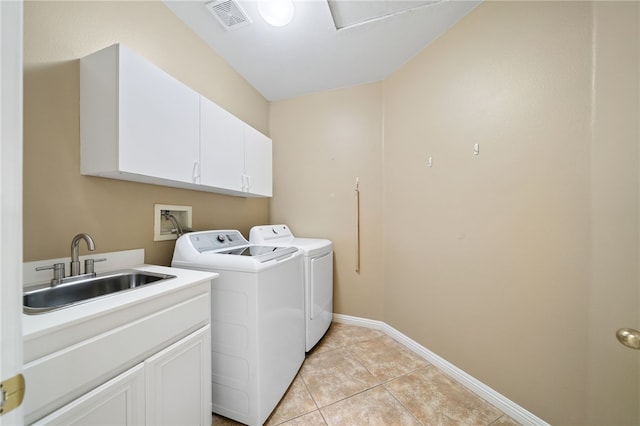 washroom with cabinet space, light tile patterned floors, visible vents, washer and dryer, and a sink