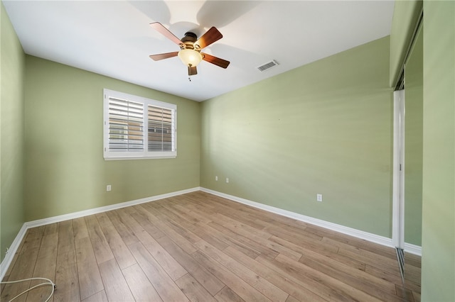 unfurnished room featuring light wood-style floors, baseboards, visible vents, and a ceiling fan