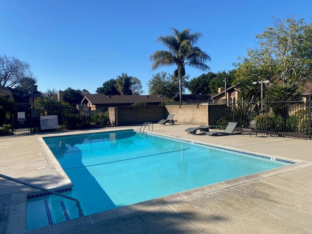 community pool with fence and a patio