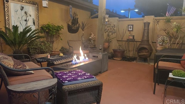 view of patio featuring fence and a fire pit