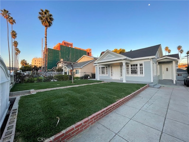 view of front of house with fence and a front lawn