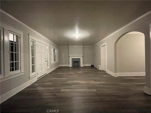 unfurnished living room with ornamental molding, a fireplace, and dark wood finished floors