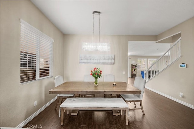 dining area featuring an inviting chandelier, dark wood-style flooring, baseboards, and stairs