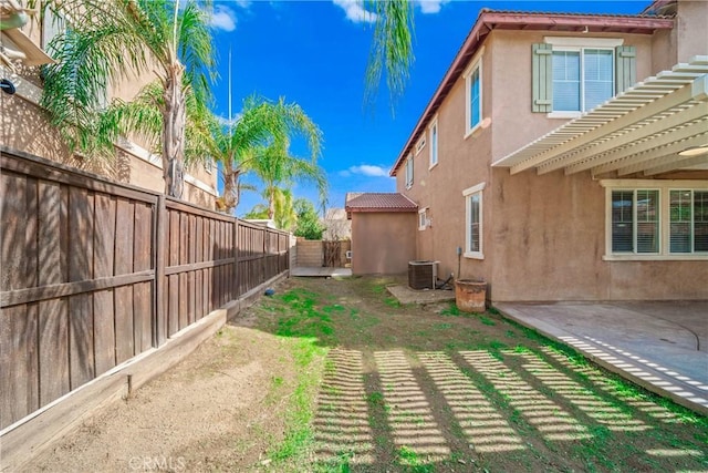 view of yard featuring a fenced backyard, central AC unit, a pergola, and a patio