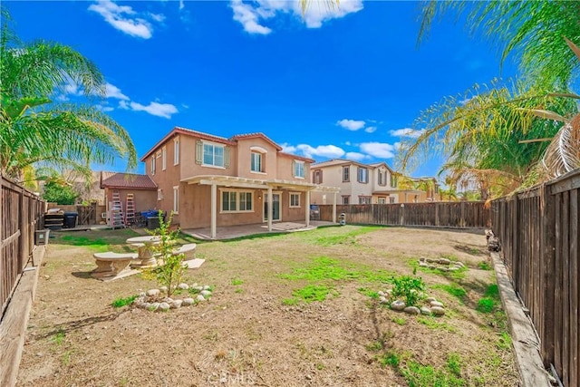 back of property featuring a patio, a fenced backyard, a residential view, a tiled roof, and stucco siding