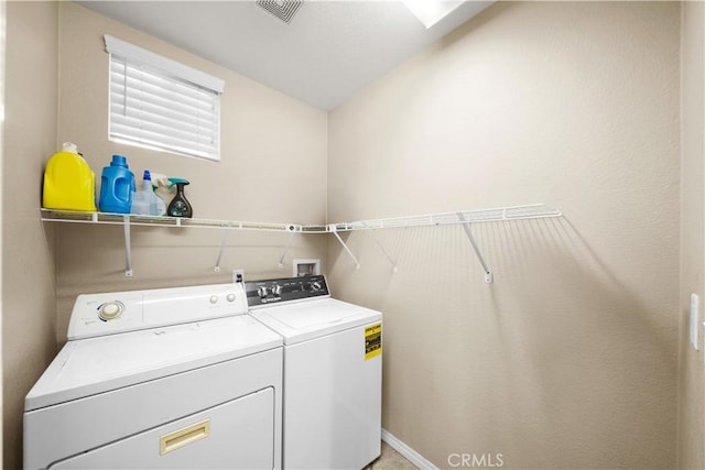 laundry room with laundry area, washing machine and dryer, and visible vents