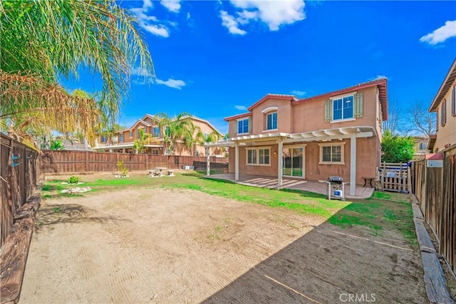 back of property with stucco siding, a patio area, a fenced backyard, and a pergola