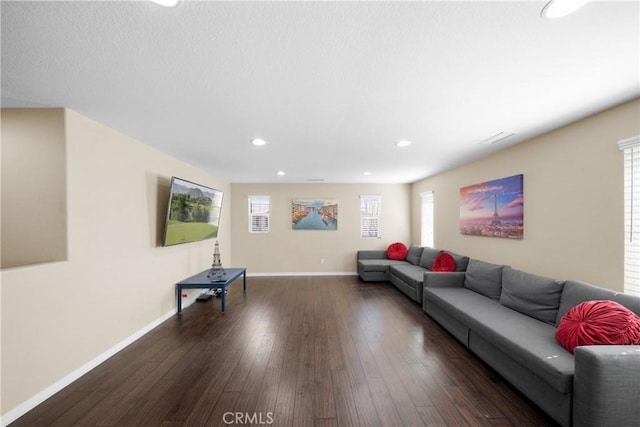 living area featuring recessed lighting, dark wood-style flooring, visible vents, and baseboards