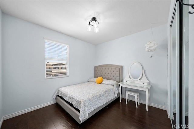 bedroom featuring baseboards and dark wood finished floors