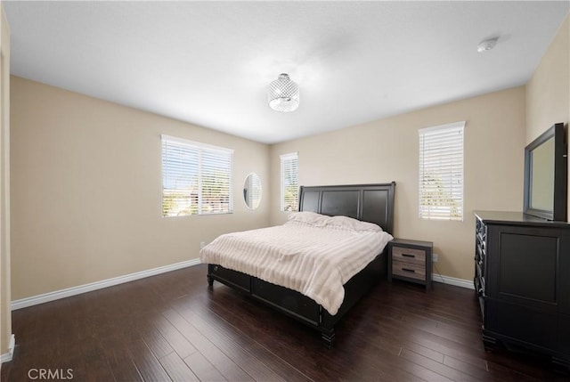 bedroom with baseboards and dark wood finished floors