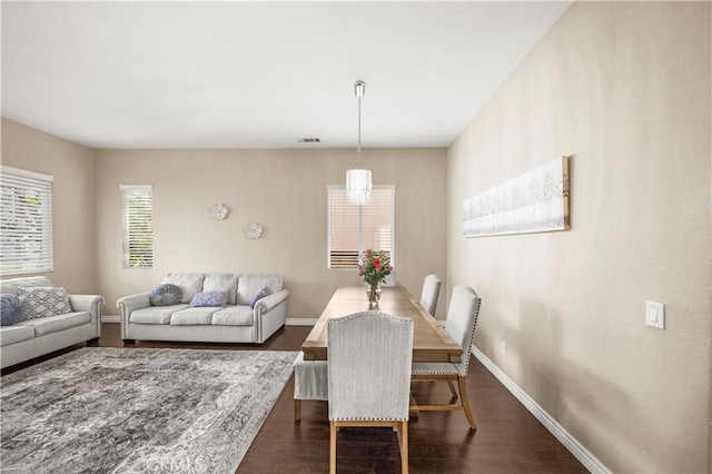 dining area with dark wood-style floors, visible vents, and baseboards