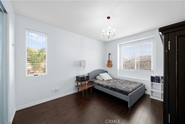 bedroom featuring dark wood-style floors, an inviting chandelier, and baseboards