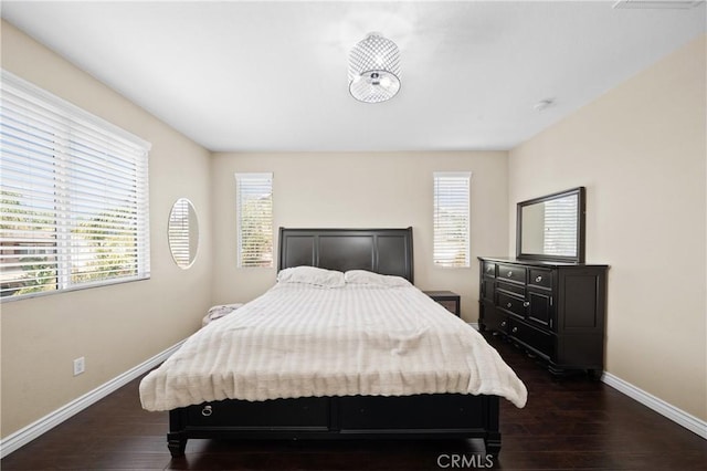 bedroom with baseboards and dark wood finished floors