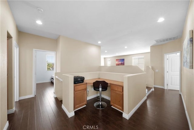 interior space with light countertops, dark wood-style flooring, visible vents, and a healthy amount of sunlight