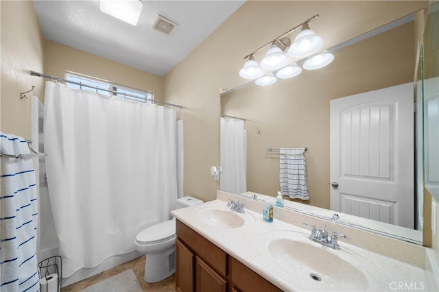 full bath with visible vents, a sink, toilet, and double vanity