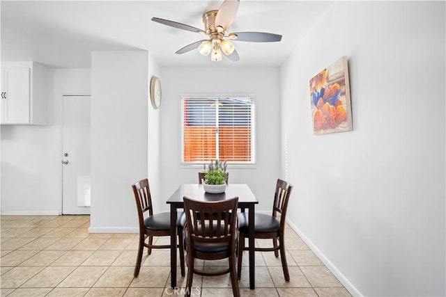 dining area with light tile patterned floors, ceiling fan, and baseboards