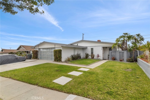 view of front of home featuring driveway, a front lawn, an attached garage, and fence