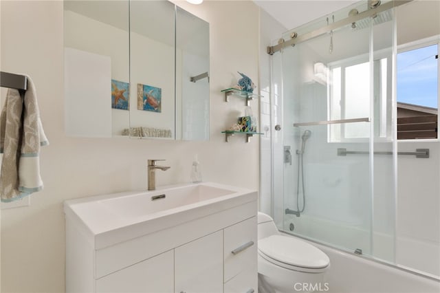 bathroom with toilet, enclosed tub / shower combo, and vanity