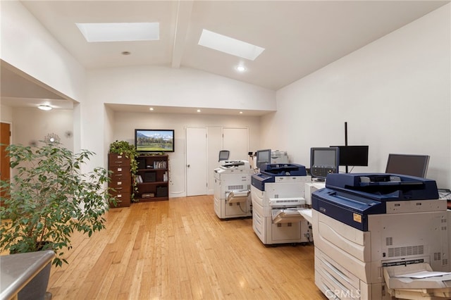 home office featuring vaulted ceiling with skylight and light wood-style flooring