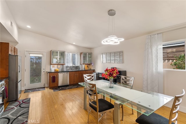 dining space with light wood-style flooring, a chandelier, vaulted ceiling, and recessed lighting