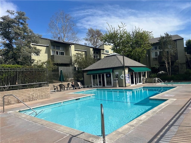 pool with fence and a patio