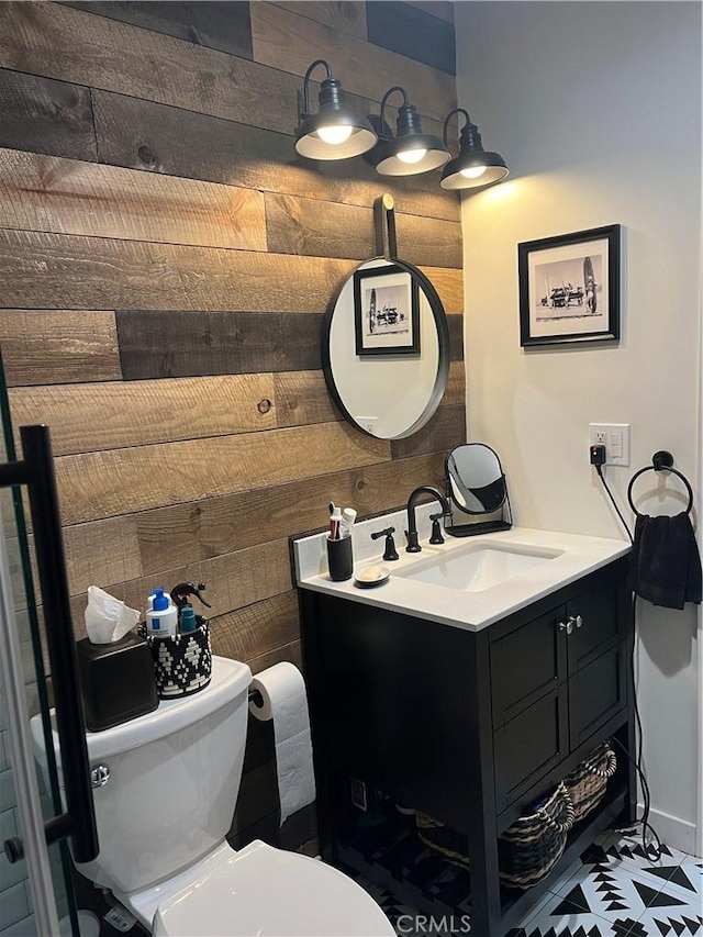 bathroom with wooden walls, toilet, and vanity