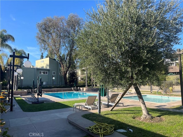 community pool with a lawn and fence