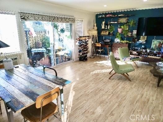 dining area with crown molding and wood finished floors