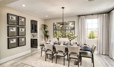 dining room with a chandelier, recessed lighting, baseboards, and wood finished floors