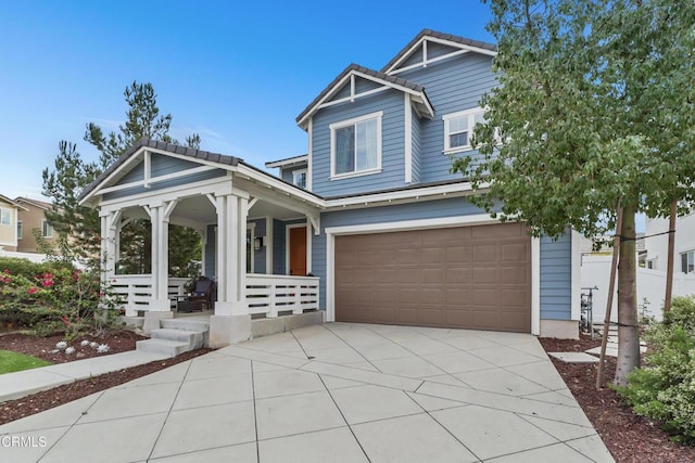 craftsman-style house featuring concrete driveway, covered porch, a tiled roof, and an attached garage