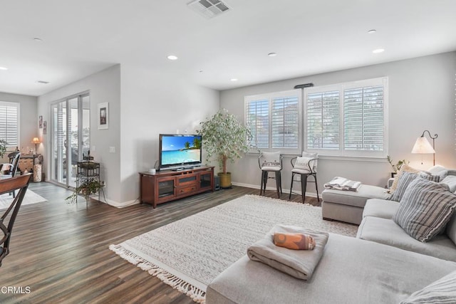 living area featuring a healthy amount of sunlight, visible vents, dark wood finished floors, and recessed lighting