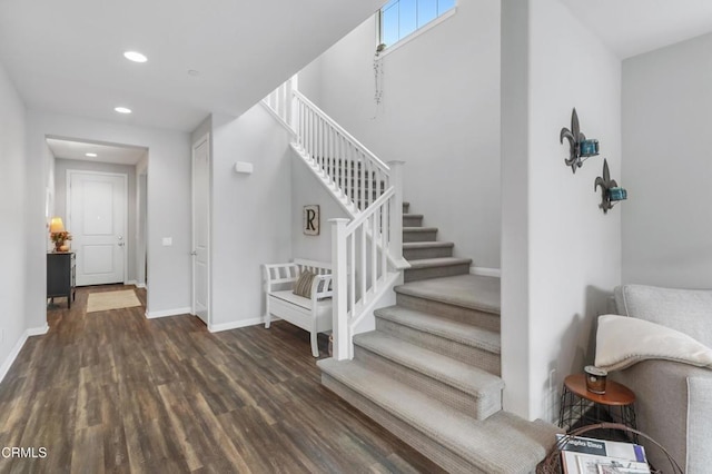 stairs featuring baseboards, wood finished floors, and recessed lighting