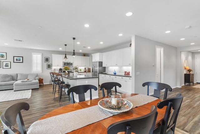 dining room with dark wood-style floors, visible vents, and recessed lighting