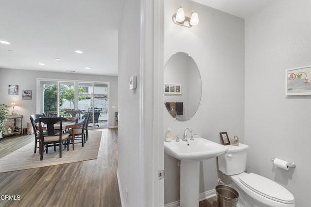 half bath featuring toilet, baseboards, wood finished floors, and recessed lighting