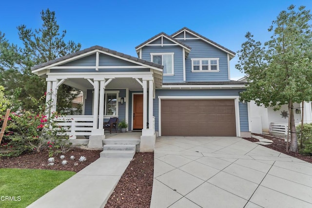 view of front of home with driveway, a porch, and an attached garage