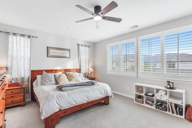 bedroom with a ceiling fan, light colored carpet, visible vents, and baseboards