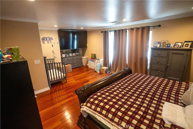 bedroom featuring dark wood-style floors, visible vents, ornamental molding, and recessed lighting