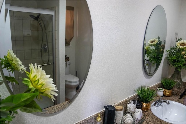 full bath with tiled shower, a sink, and toilet