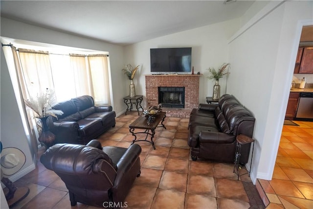 living room with lofted ceiling, dark tile patterned floors, a fireplace, and baseboards