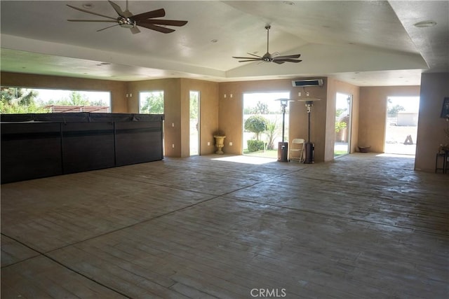 unfurnished living room featuring lofted ceiling, ceiling fan, and a wealth of natural light