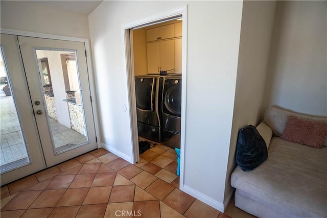 interior space featuring cabinet space, washer and clothes dryer, baseboards, and light tile patterned flooring