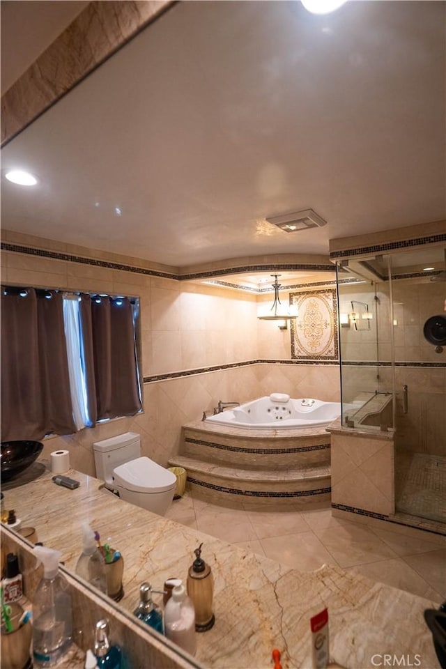 full bathroom featuring a stall shower, toilet, tile patterned floors, a whirlpool tub, and tile walls