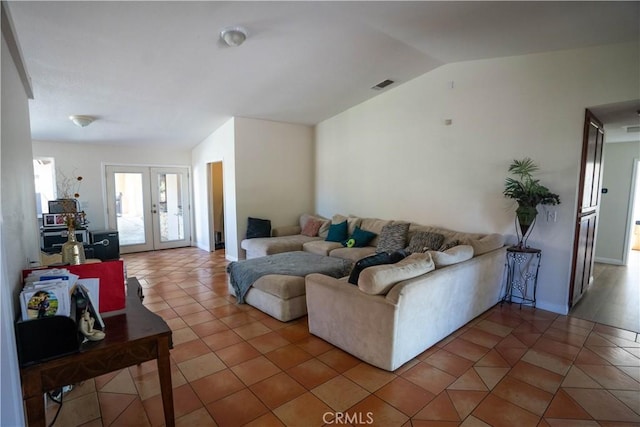 tiled living room featuring vaulted ceiling, french doors, and visible vents