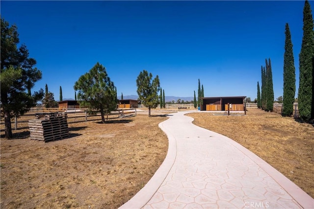 view of property's community with a rural view, an outdoor structure, and an exterior structure