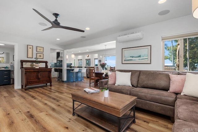 living area with plenty of natural light, wood finished floors, and a wall mounted air conditioner