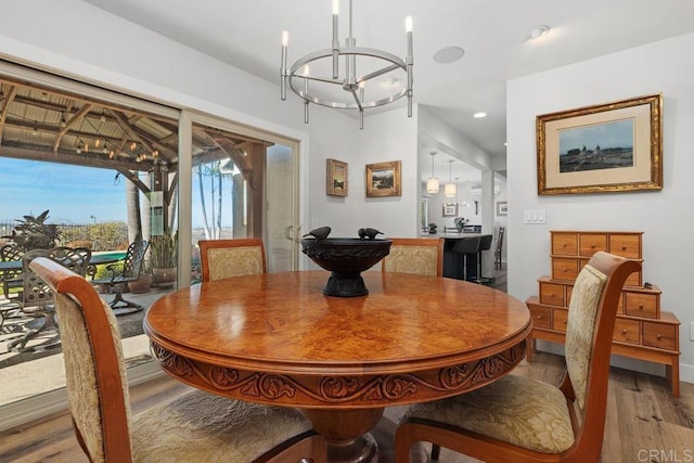 dining room with light wood-style floors, recessed lighting, and a notable chandelier