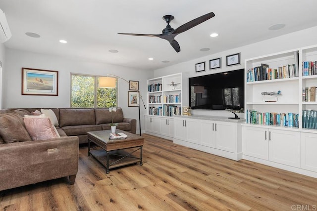 living room with a ceiling fan, recessed lighting, light wood-style flooring, and built in features