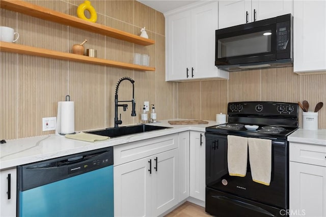 kitchen with white cabinets, light stone counters, black appliances, open shelves, and a sink